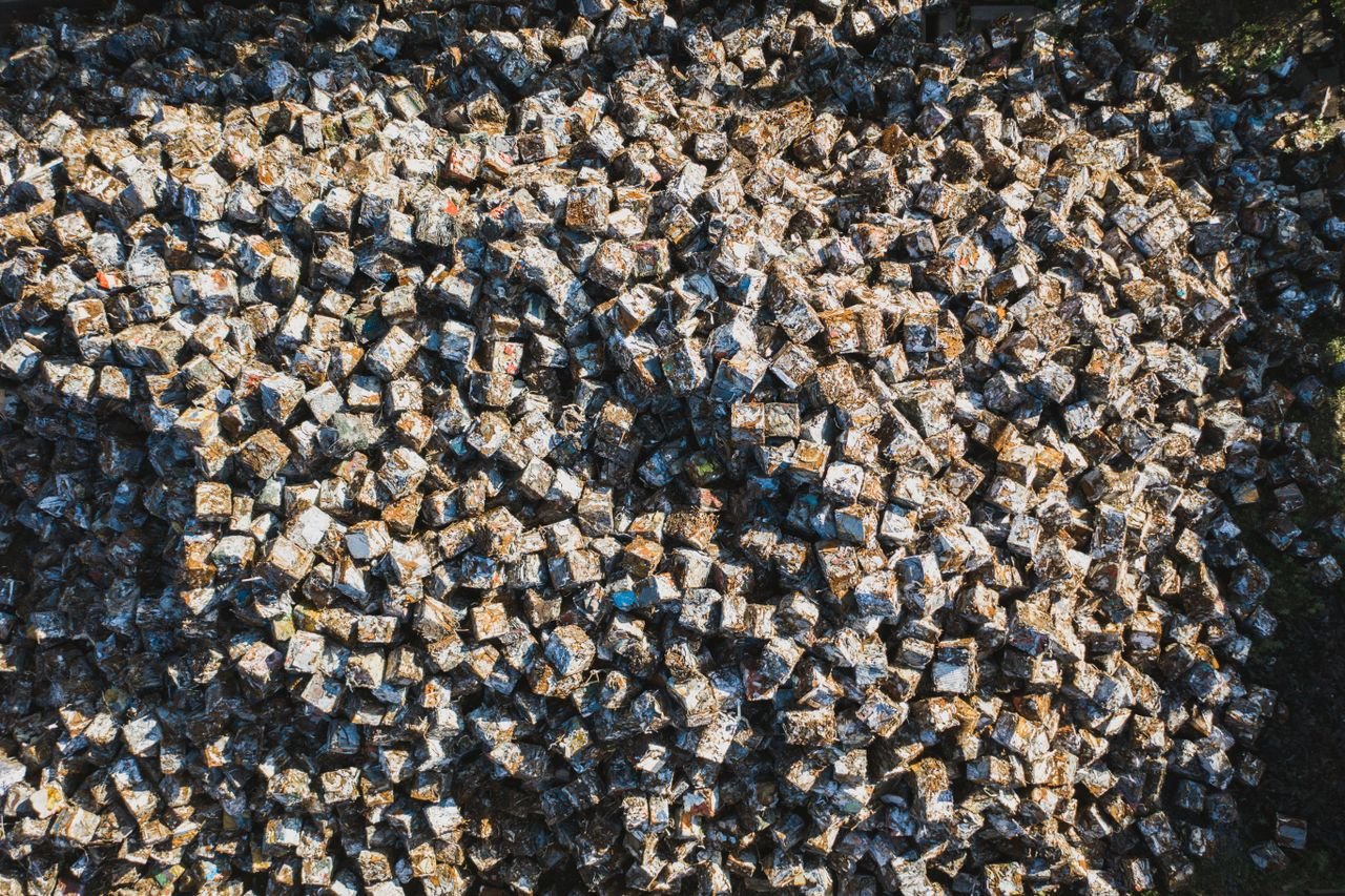 Home Aerial perspective of densely packed metal scrap cubes in an industrial setting, highlighting recycling.