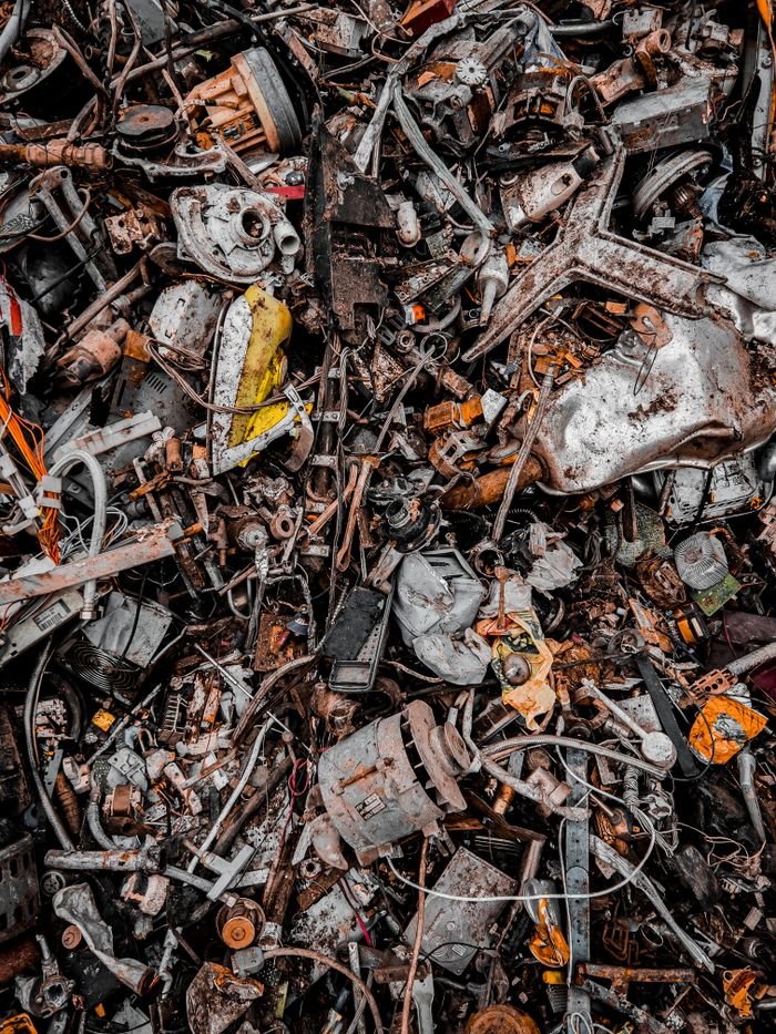 Home A chaotic pile of metal scrap and waste, showcasing decaying and rusty components in an industrial setting.